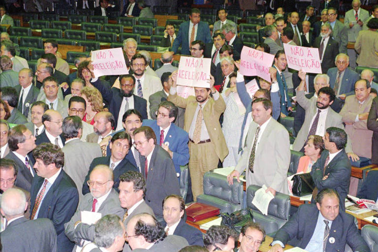 Deputados federais erguem cartazes de protesto contra a reeleição durante votação da PEC (Proposta de Emenda à Constituição) sobre o tema na Câmara dos Deputados, em Brasília