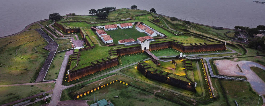 Fortaleza vista de cima, com construções ao fundo e o rio Amazonas.