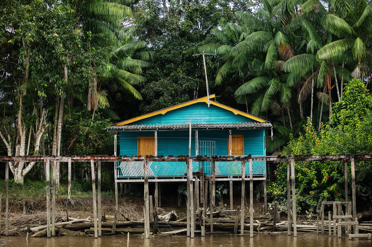 Casa azul com telhado amarelo sob rio.