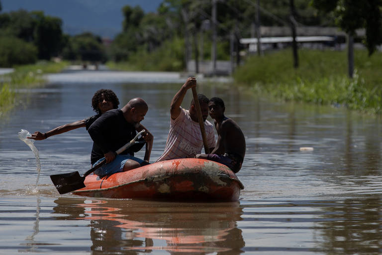 Moradores andam de barco pelo bairro Amapá, em Duque de Caxias (RJ) 