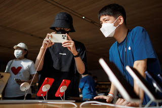 FILE PHOTO: A man holds an iPhone 14 as Apple Inc's new models go on sale at an Apple store in Beijing