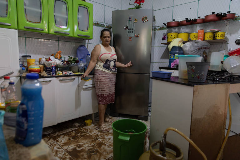 Mulher mostra móveis arrastados e chão da cozinha enlameado