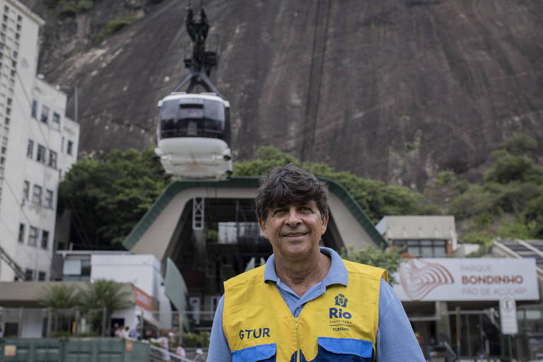 Homem branco sorridente, de colete da Prefeitura do Rio de Janeiro, sorri