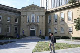 A student walks in front of the University of Toronto, St. George campus
