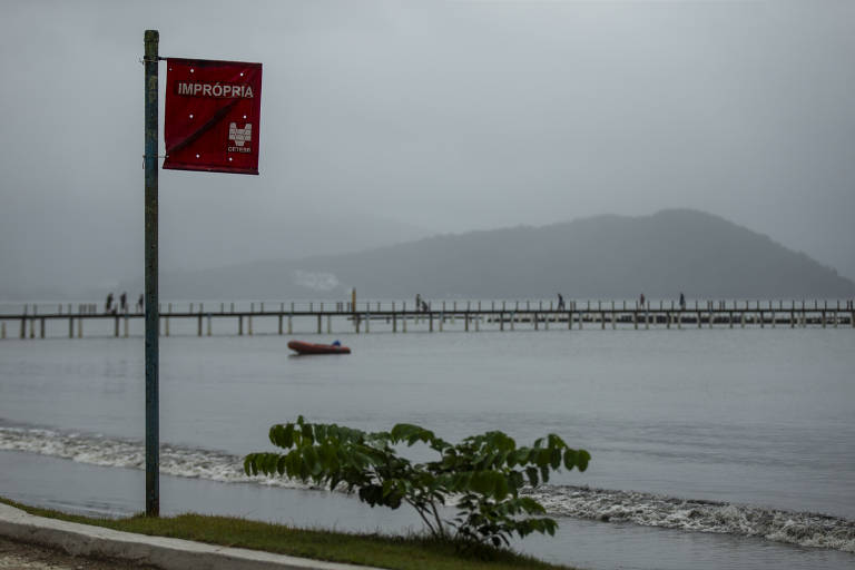 Bandeiras vermelhas da Cetesb espalhadas por toda orla indicando que a praia do Itaguá, no centro de Ubatuba, está imprópria para banho.