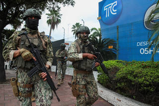 Members of security forces stand guard outside local TV station TC following Ecuador's President Daniel Noboa's visit, in Guayaquil