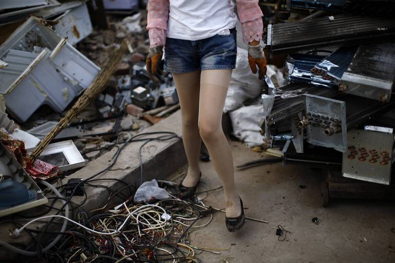 Reciclador procura material eletrônico em uma área de Pequim