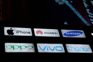 FILE PHOTO: The signs of smartphone makers Apple, Huawei, Samsung, Oppo, Vivo and Huawei's Honor are displayed outside a store in Beijing