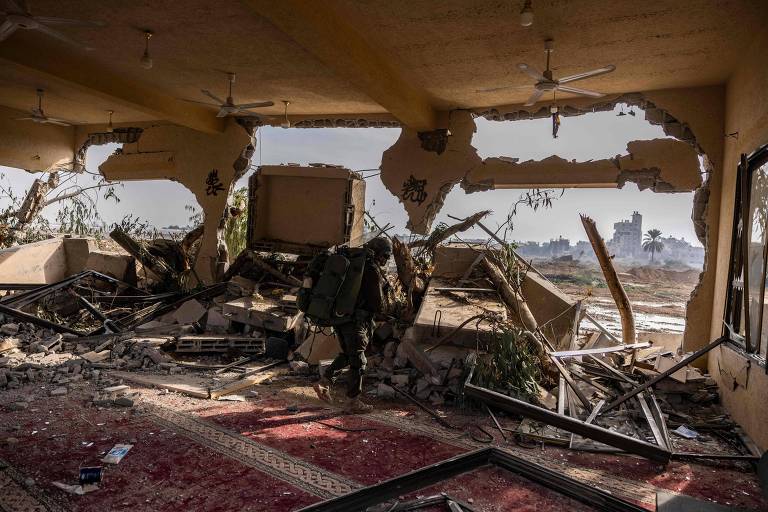 Um soldado israelense em prédio destruído em Bureij, na Faixa de Gaza; a imagem foi feita em visita controlada e editada posteriormente sob supervisão do Exército de Israel