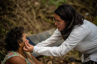 Dr. Juliana Quintero inspects lesions on Maria de las Mercedes Gonzalez, a gold miner on the Cauca River, in Medellin, Colombia, Jan. 21, 2023. (Federico Rios/The New York Times)