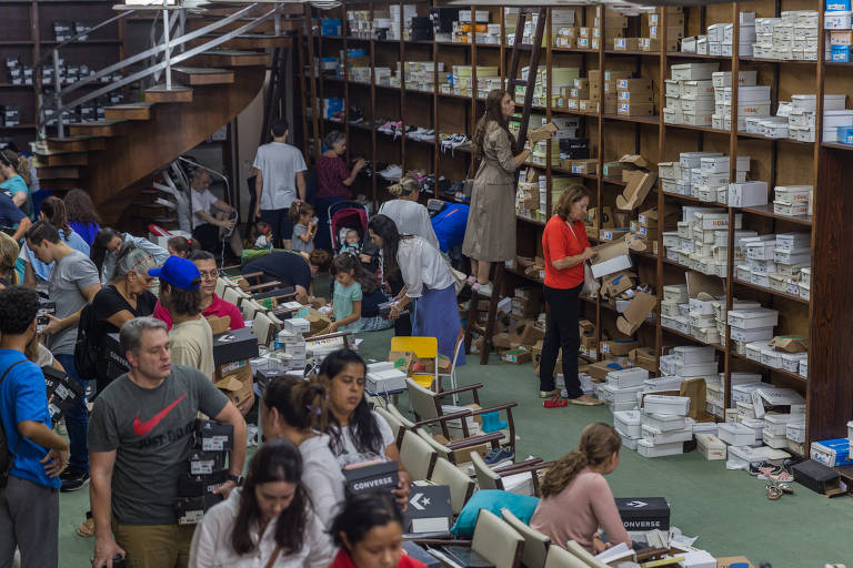Clientes da Casa Tody experimentam calçados em loja caótica