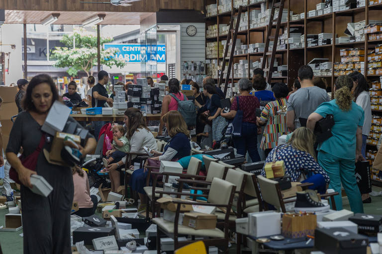 Clientes da Casa Tody experimentam calçados em loja caótica