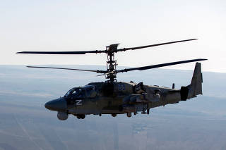 A Russian military helicopter patrols over Kobani