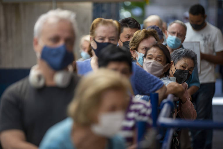 Idosos com máscara contra a Covid fazem fila para tomar vacina