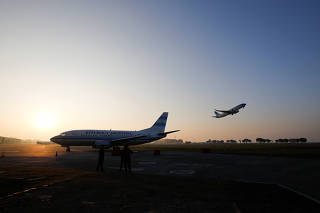 The Argentine presidential plane ARG-02 is seen on the tarmac while an Aerolineas Argentinas plane is taking off at the Jorge Newbery International Airport in Buenos Aires