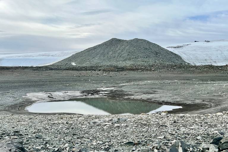 Lago Boeckella, na Antártida, é apenas um pequeno buraco com água cercado por um solo pedregoso. Ao fundo, uma geleira se estende no horizonte
