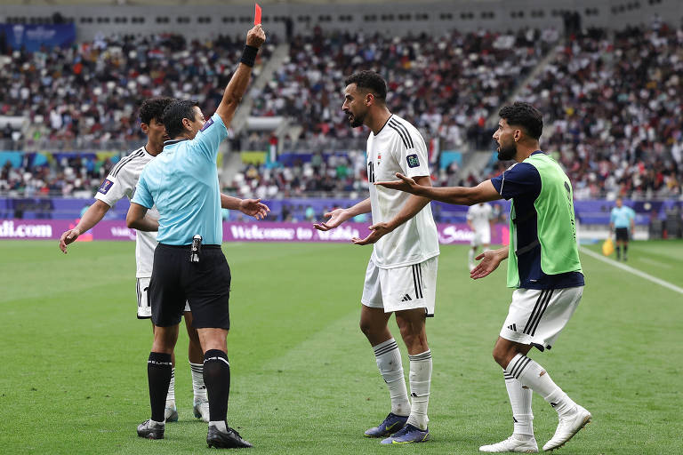 O árbitro Alireza Faghani ergue o braço direito e exibe o cartão vermelho ao artilheiro do Iraque, Aymen Hussein, em jogo das oitavas de final da Copa da Ásia