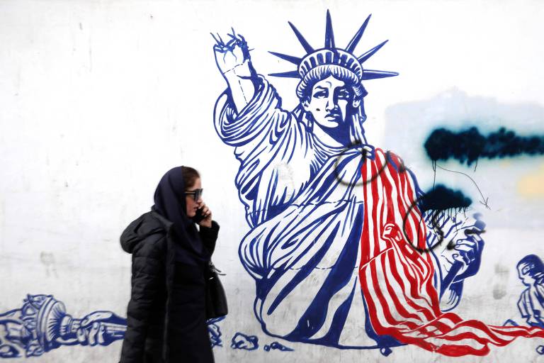 Iraniana passa por grafite da Estátua da Liberdade destruída, pintado no muro da antiga embaixada dos EUA em Teerã