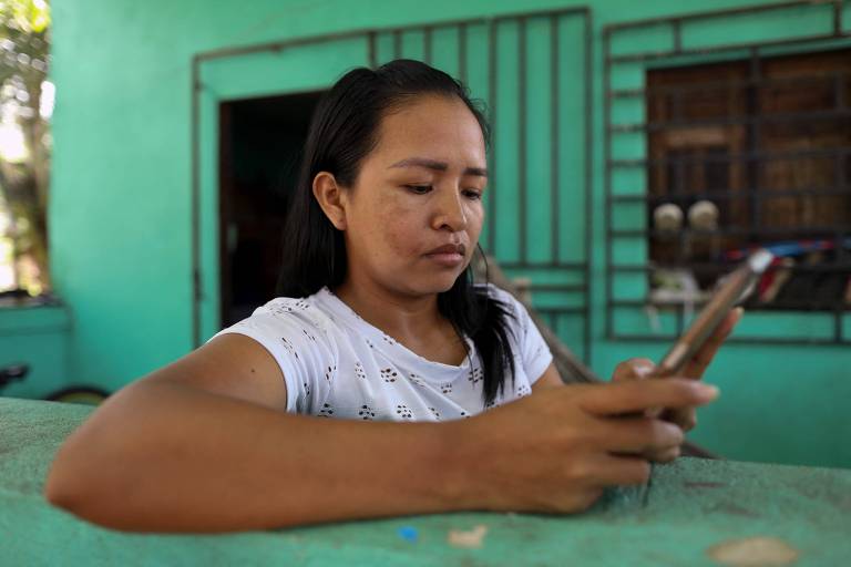 Cristina Quirino Mariano usa o aplicativo Linklado em seu celular na cidade de Manaus