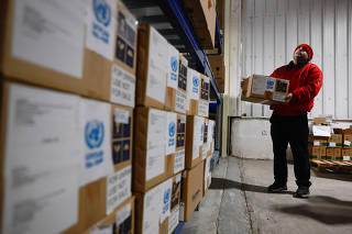 An UNRWA worker moves a box of humanitarian aid in a warehouse of the West Bank field office complex of UNRWA, in the Sheikh Jarrah neighborhood of East Jerusalem
