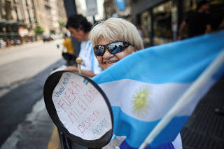A demonstrator bangs a pan outside the National Congress as lawmakers debate on Argentina's President Javier Milei's 