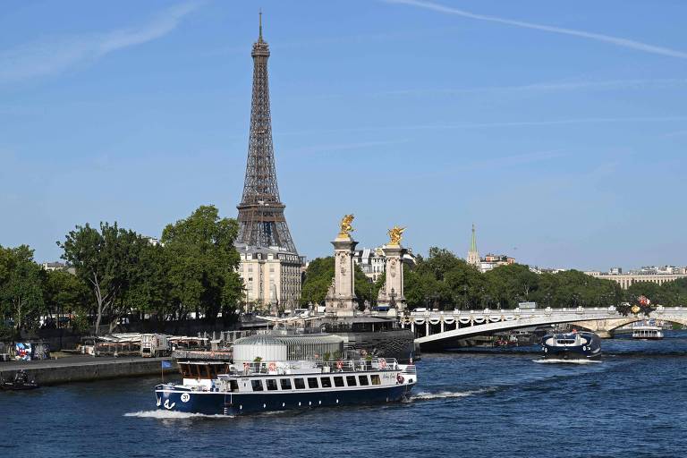 Um barco passa pela torre Eiffel, no rio Sena, durante testes para a abertura da Olimpíada de Paris



