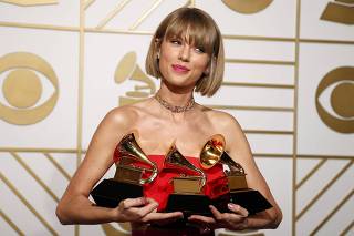 Taylor Swift poses with her awards during the 58th Grammy Awards in Los Angeles