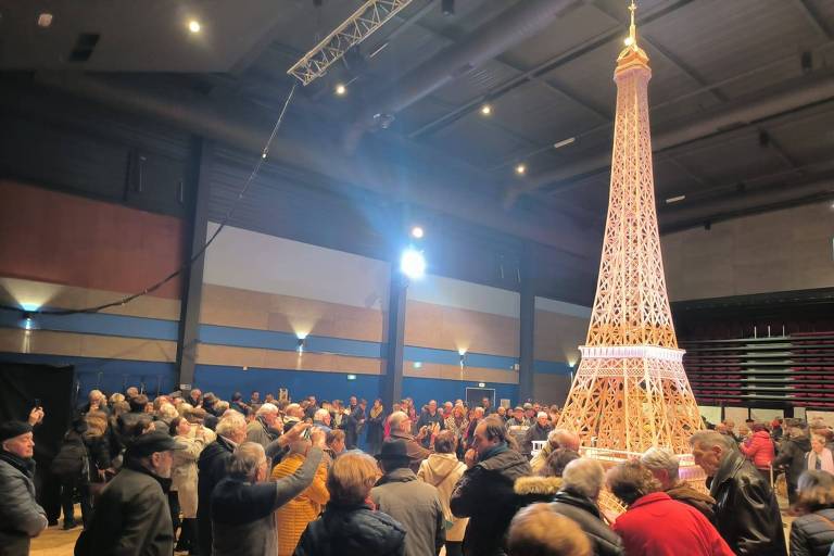 Multidão observa réplica de Torre Eiffel feita de palitos