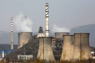 FILE PHOTO: Smoke rises from chimneys at a steel factory in Beijing