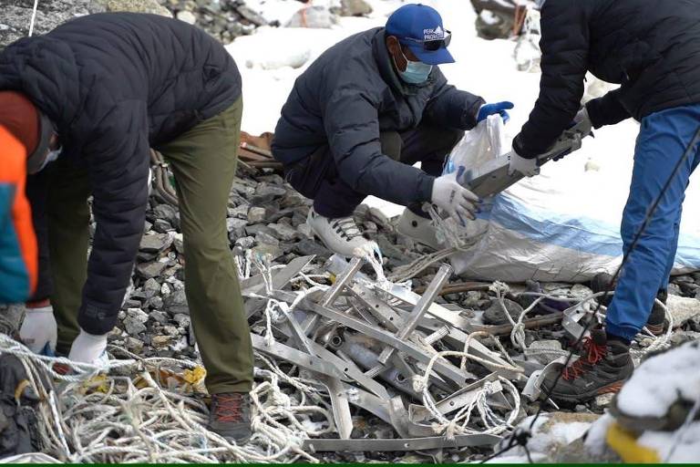 Escadas e cordas abandonadas sendo coletadas em acampamento no Monte Everest