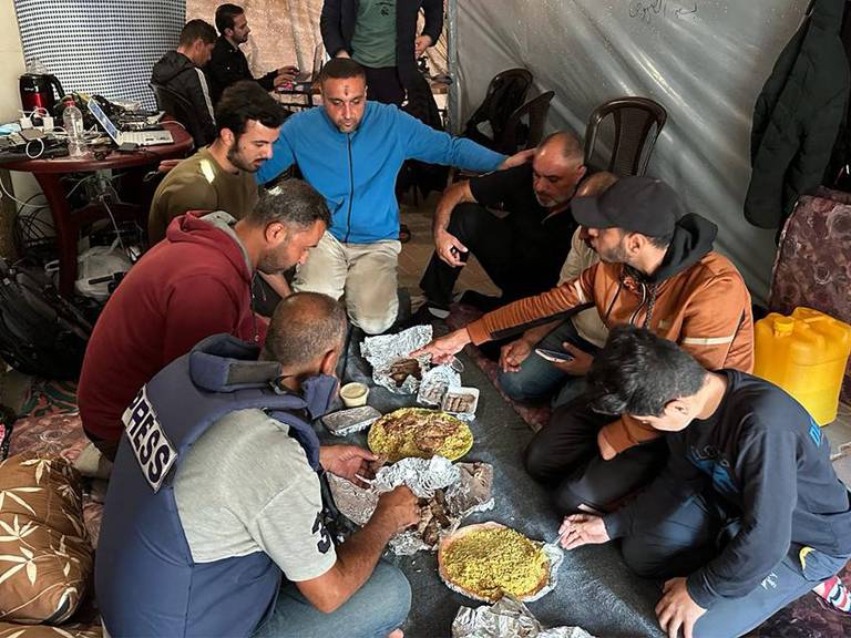 Jornalistas da AFP e familiares compartilham uma refeição em 10 de dezembro de 2023, em Rafah, no sul da Faixa de Gaza 