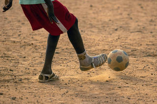 A young soccer player wears plastic sandals named lk, in Abidjan, Ivory Coast, on Jan. 27, 2024. (Joao Silva/The New York Times)