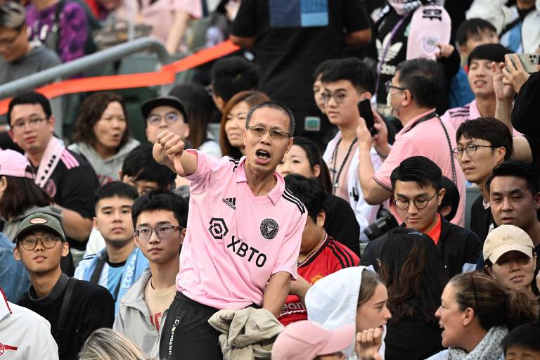 Fã com a camisa cor de rosa do Inter Miami faz sinal de negativo com o polegar em estádio de Hong Kong