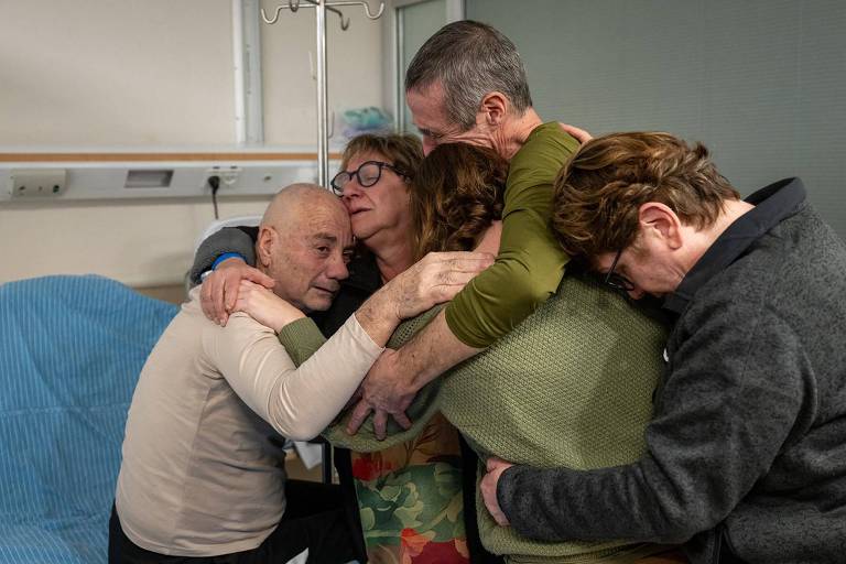 Louis Hare (de branco, à esq.) abraça familiares em hospital de Israel após ser libertado de cativeiro em Gaza