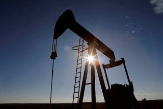 FILE PHOTO: The sun is seen behind a crude oil pump jack in the Permian Basin in Texas, U.S.