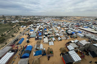 Displaced Palestinians who fled their houses due tor Israeli strikes take shelter in a tent camp in Rafah