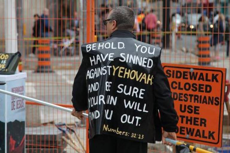 Pregador cristão em rua de Toronto, Canadá, com vestes que citam escrituras bíblicas