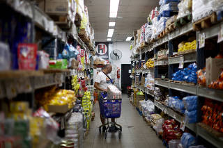A man checks prices in a supermarket, in Buenos Aires