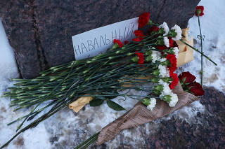 People gather at the monument to the victims of political repressions following the death of Alexei Navalny in Saint Petersburg