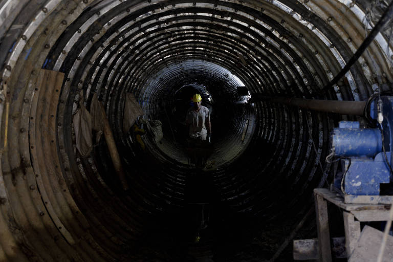 Imagem mostra operário dentro de um túnel escuro