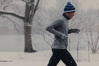 A runner braves the snow in Prospect Park in Brooklyn in February 2022. (Keith E. Morrison/The New York Times)
