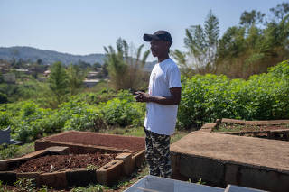 Manqoba Motsa stands near his grandmother's grave, where he and his father argued during her funeral, in Matsapha, Eswatini, April 26, 2023. (Joao Silva/The New York Times)