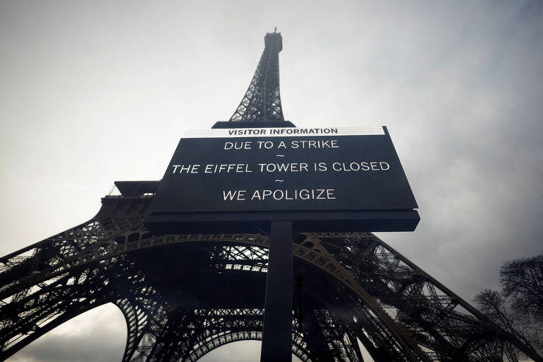 Placa na torre Eiffel que diz: "Devido a uma greve, a torre está fechada. Pedimos desculpas"