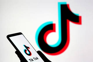FILE PHOTO: Person holds a smartphone with Tik Tok logo displayed in this picture illustration
