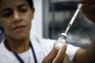 Profissional prepara dose da vacina da dengue para aplicação em UBS