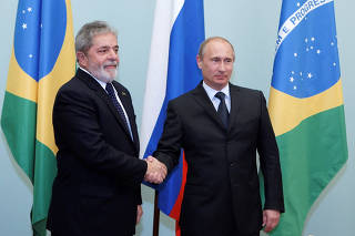 FILE PHOTO: Brazil's President Luiz Ignacio Lula da Silva shakes hands with Russia's Prime Minister Putin as they meet in Moscow