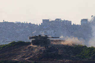 An Israeli tank fires into the Gaza Strip from Israel, as seen from Israel