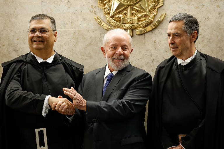 Da esquerda para a direita, lado a lado, Flávio Dino, Lula e Luís Roberto Barroso; Lula cumprimenta Dino