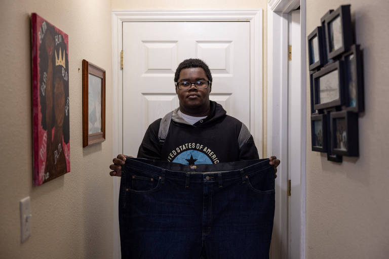 Billy Small é um jovem negro; ele segura uma calça larga que usava antes de emagrecer