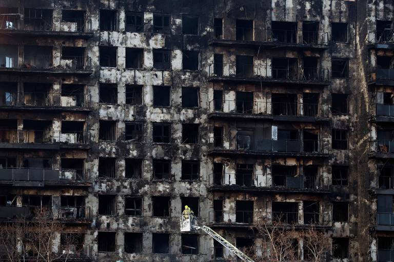 Bombeiro vistoria prédio destruído por chamas